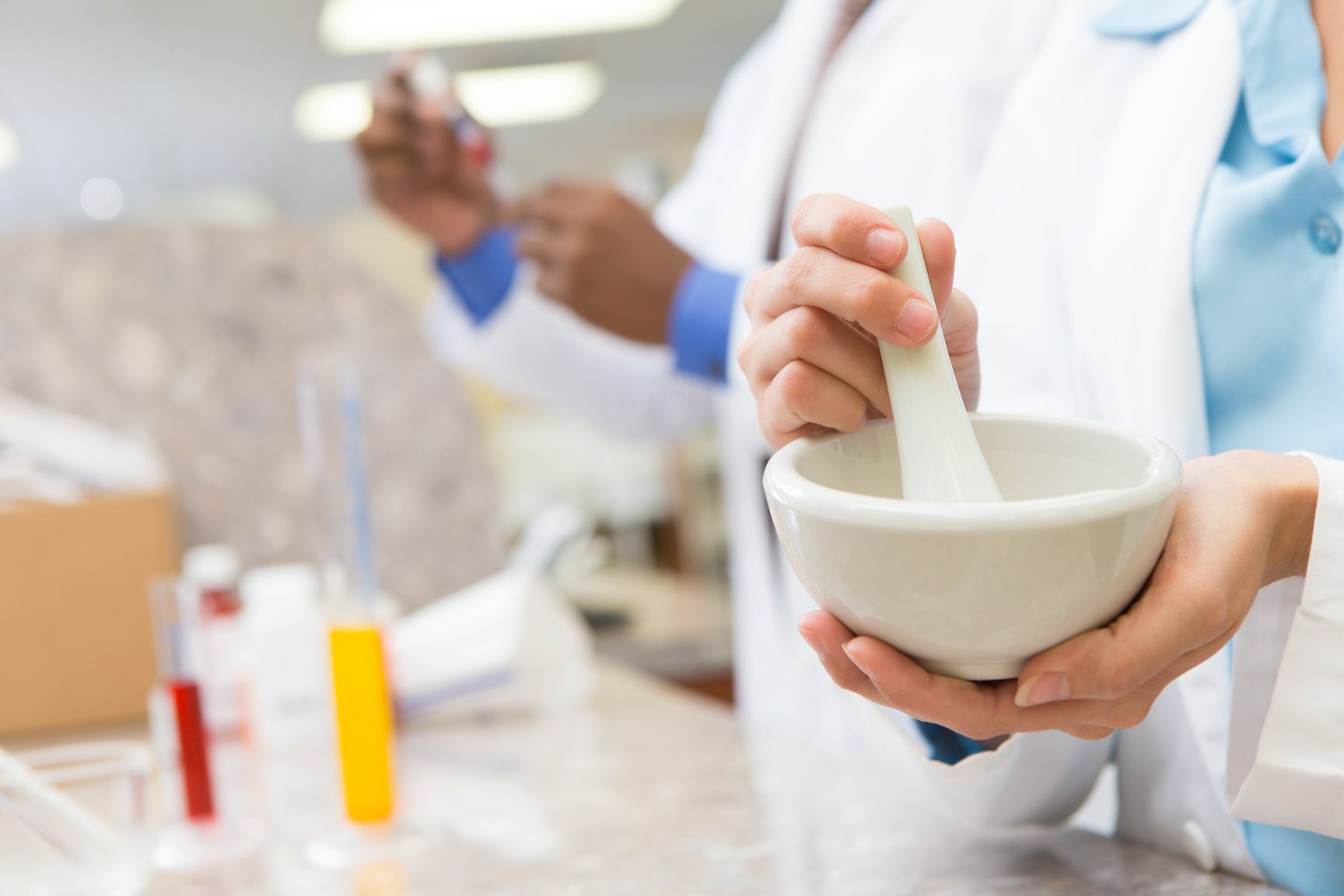 Compounding pharmacist creating specialized prescription medication in pharmacy lab