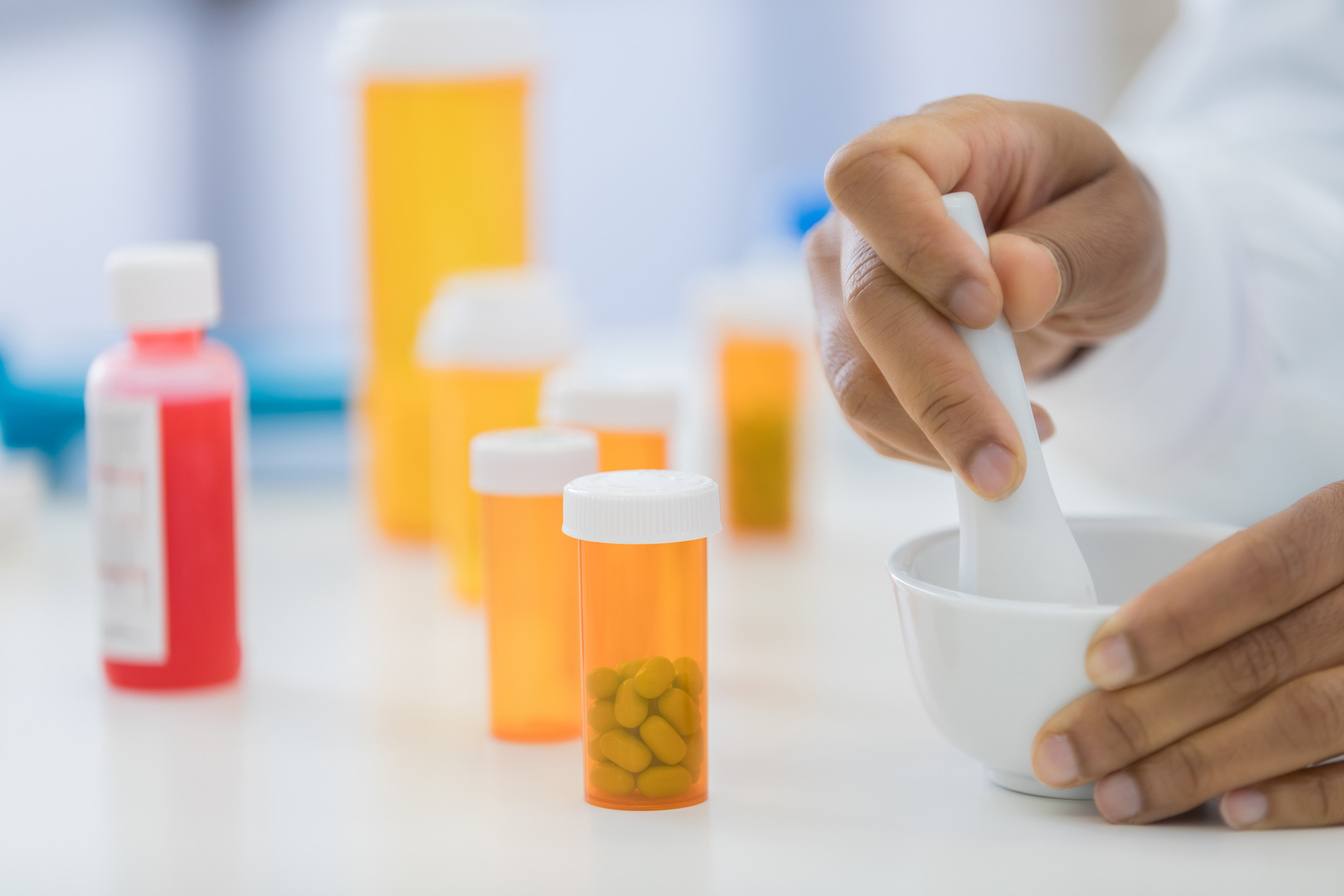 Compounding pharmacist uses mortar and pestle