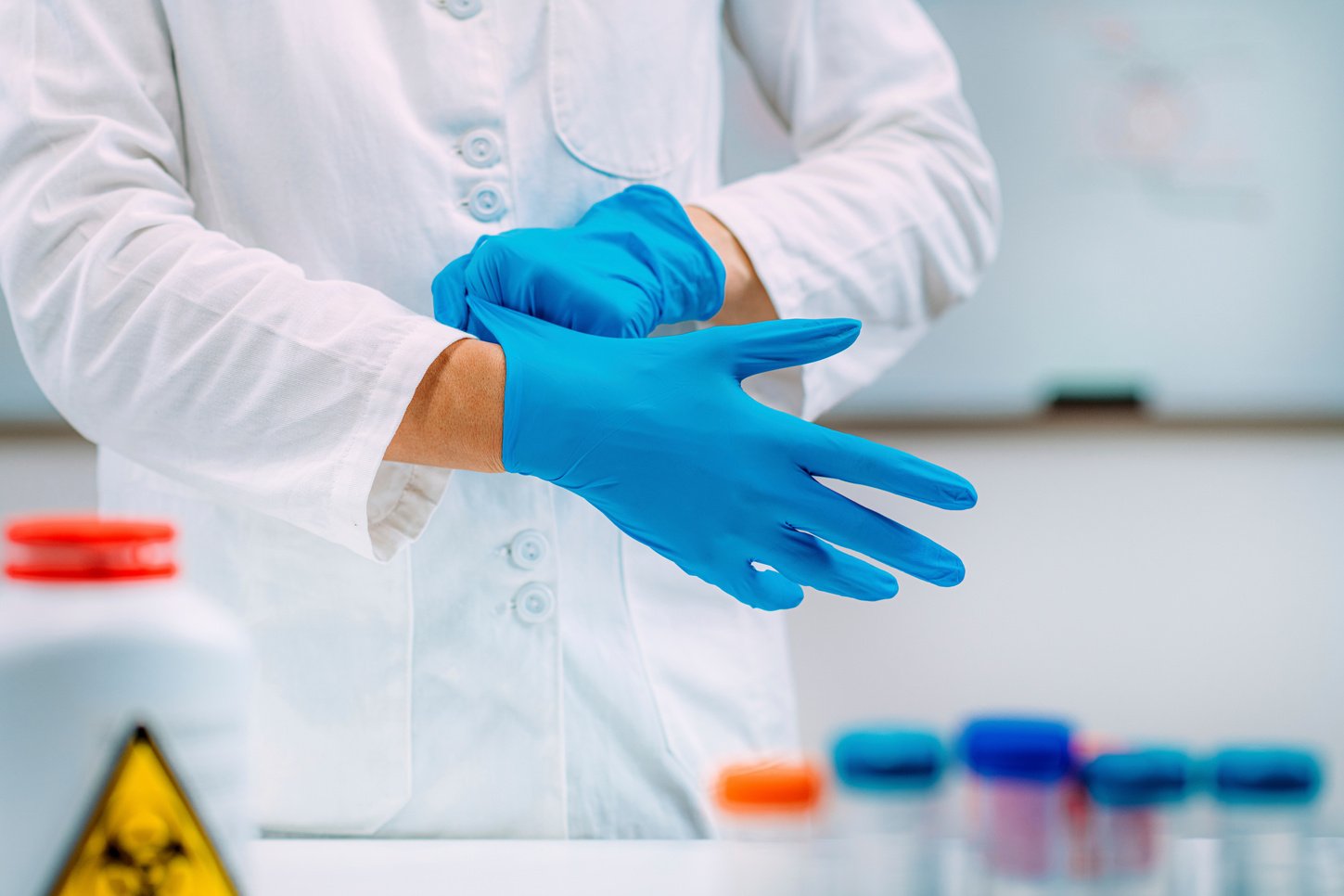 Lab technician putting on protective gloves